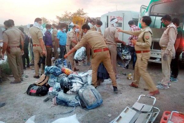 यूपी के औरैया में सड़क दुर्घटना के दौरान 24 प्रवासी श्रमिकों की मौत के बाद घटनास्थल का निरीक्षण करते पुलिस अधिकारी