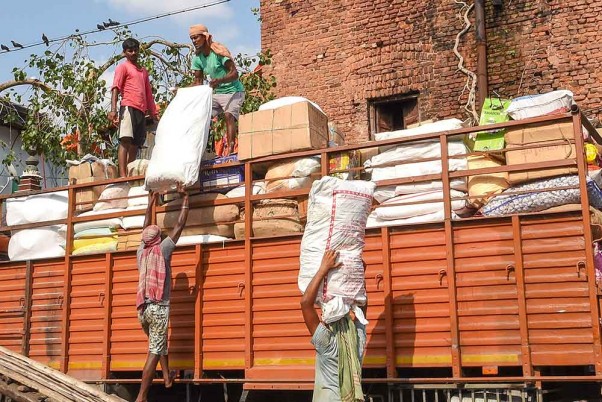 कोलकाता में लॉकडाउन के चौथे चरण के दौरान बुर्राबाजार में एक ट्रक पर सामान लोड करते मजदूर