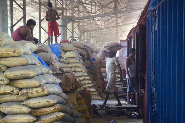 लॉकडाउन के बीच नवी मुंबई में कंटेनर कॉरपोरेशन ऑफ इंडिया लिमिटेड यार्ड में मालगाड़ी से चावल की बोरियां उतारते मजदूर