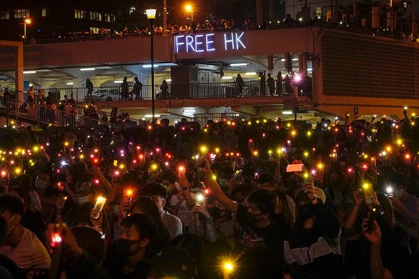 हांगकांग में एक रैली के दौरान अपने फोन से प्रकाश दिखाते मेडिकल वॉलंटियर