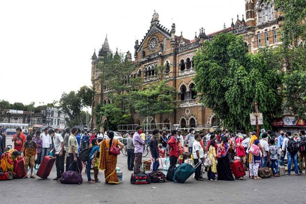 मुंबई में जारी लॉकडाउन के दौरान अपने घर लौटने के लिए छत्रपति शिवाजी महाराज टर्मिनस के बाहर कतार में खड़े प्रवासी श्रमिक