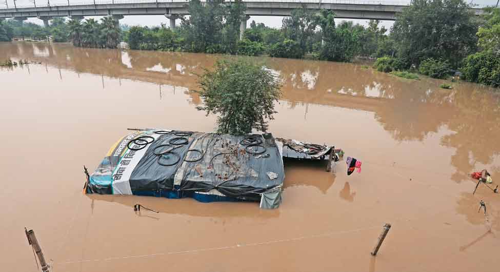 मयूर विहार की मेट्रो लाइन और यमुना के खादर में डूबी झोंपड़ी  