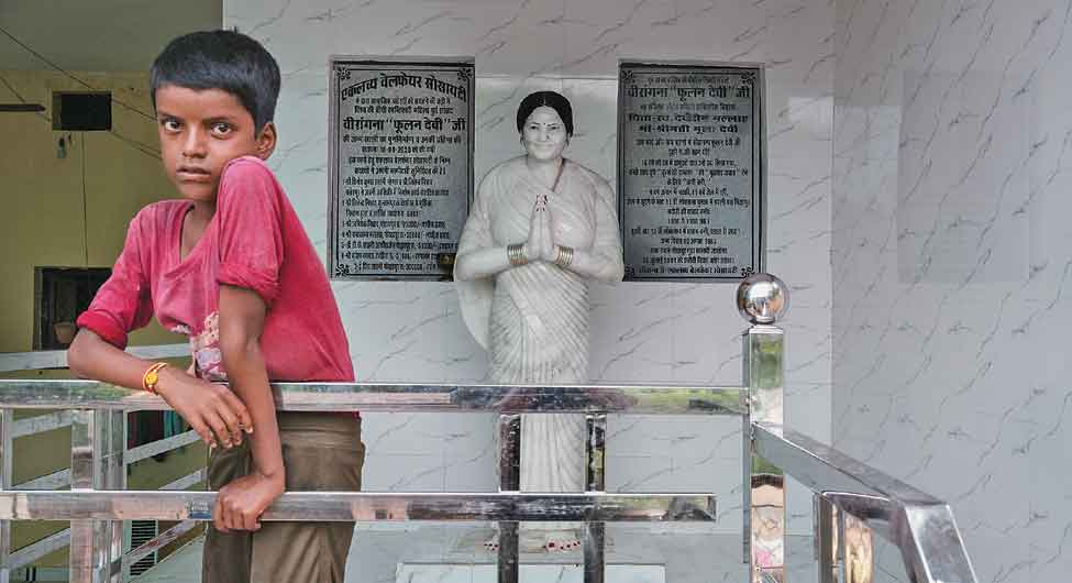 फूलन देवी के पुश्तैनी घर में लगी उनकी मूर्ति के सामने उनका भतीजा निशांत