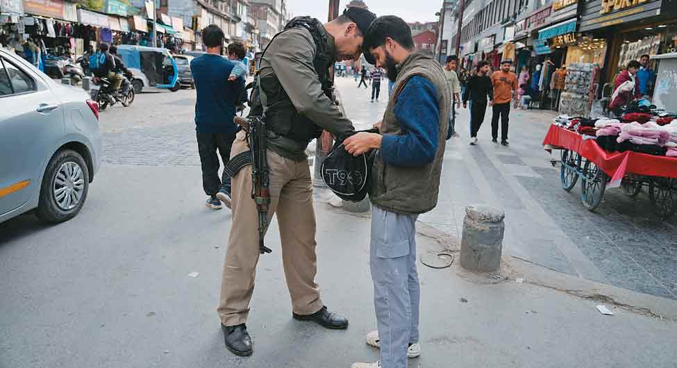 चौकसीः श्रीनगर में क्लॉक टॉवर के पास राहगीर की तलाशी लेता जवान