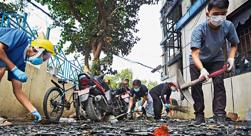 बवाल के बादः काठमांडू में विद्रोही युवाओं के थाने को जला देने के बाद सफाई करते लोग