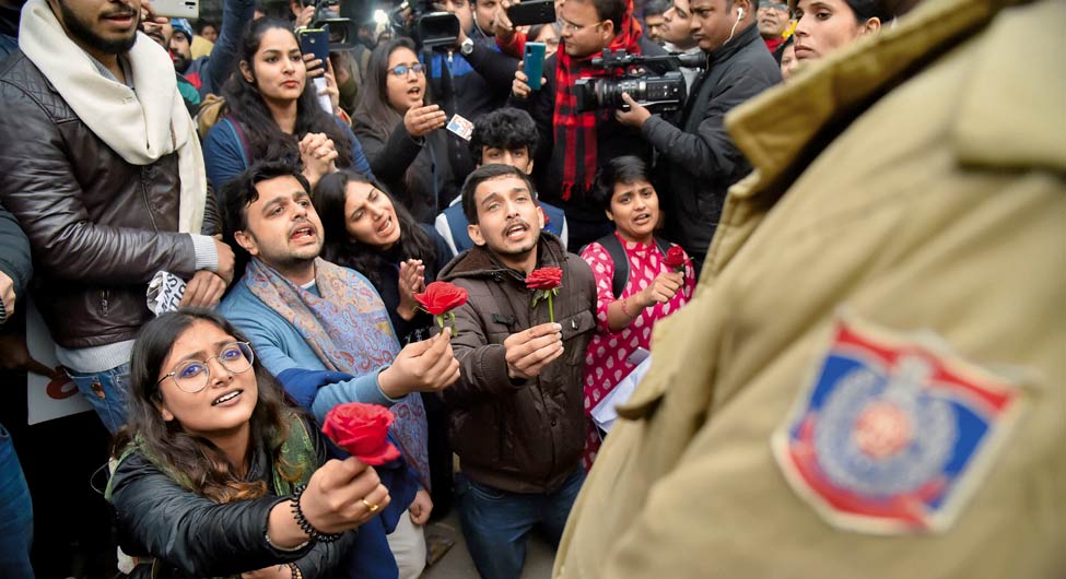 मुद्दा 2019  नागरिक प्रश्न, ऐसा भी विरोध: नई दिल्ली में नागरिकता संशोधन कानून के विरोध में दिल्ली पुलिस को गुलाब का फूल देते छात्र