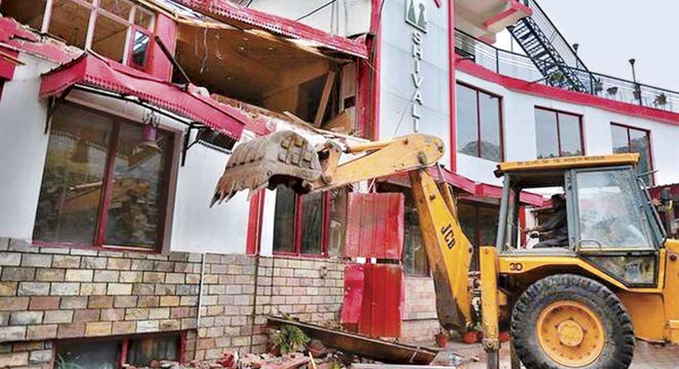 कार्रवाईः कसौली के पास धरमपुर में एक होटल के अवैध हिस्से को तोड़ती जेसीबी