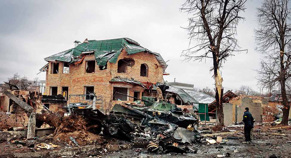 रूसी हमले के बाद टूटा हुआ घर देखता एक यूक्रेनी नागरिक